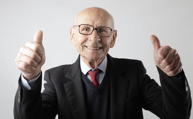 An older man with thumbs up "yes you can grow"